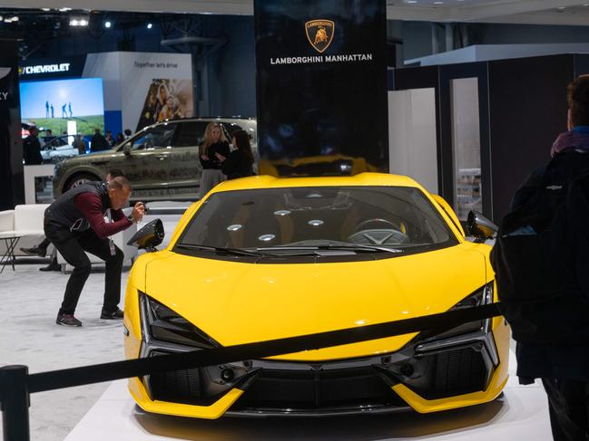 NEW YORK, NEW YORK - MARCH 27: People look at the new Lamborghini at the New York International Auto Show on March 27, 2024 in New York City. The annual show, which opens to the public on March 29th, is one of the largest auto shows in the world and reveals numerous new car models for both the public and the media. This year's show includes an emphasis on new electric and hybrid models.   Spencer Platt/Getty Images/AFP (Photo by SPENCER PLATT / GETTY IMAGES NORTH AMERICA / Getty Images via AFP)