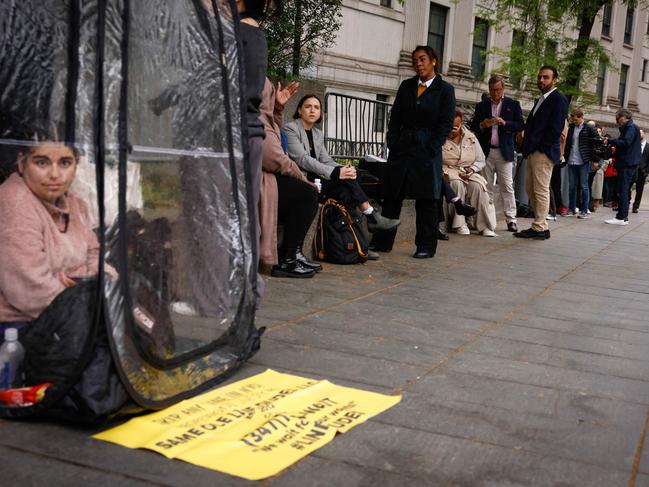 A woman sits on a shelter as people wait in line outside the Southern District of New York Federal Court, as jury selection begins in Combs' federal sex crimes trial. Picture: AFP