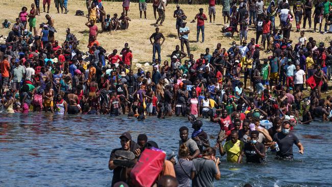 Haitian migrants, part of a group of over 10,000 people staying in an encampment on the US side of the border, cross the Rio Grande river to get food and water in Mexico in September 2021. Picture: Paul Ratje/AFP