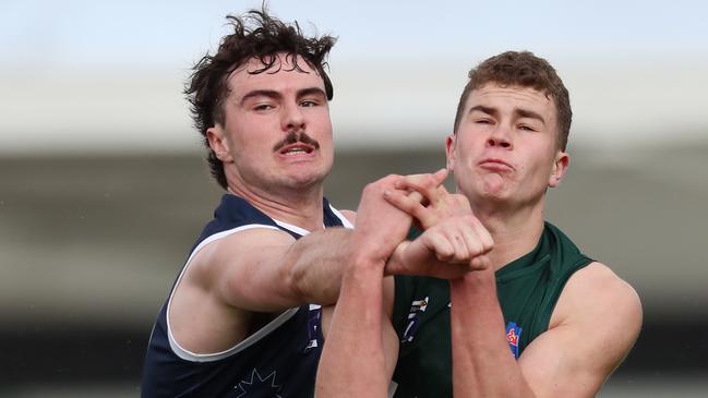 Ballarat’s Liam Howard punches the ball from Hampden’s Hamish Cook. Picture Yuri Kouzmin