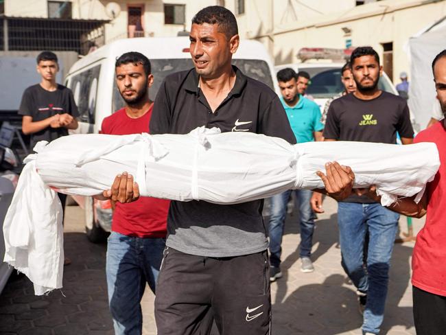 A man carries the body of Abdelrahman Youssef Abu Galambo, an 11-year-old child who died during Israeli bombardment in al-Bureij in the central Gaza Strip. Picture: AFP