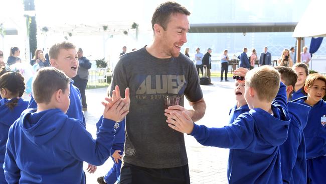 NSW Blues State of Origin player James Maloney (centre) high five members of the junior State of Origin team.