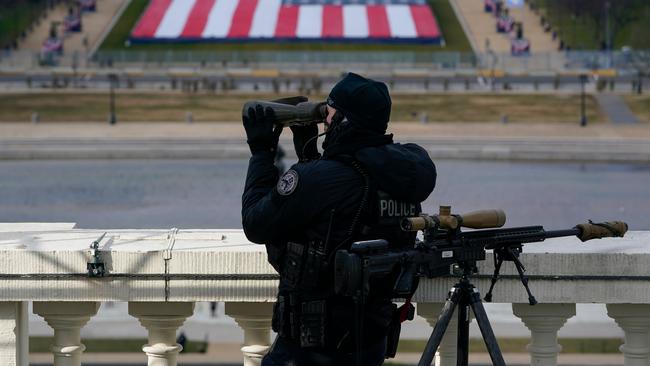 A law enforcement personnel monitor watches from a balcony during the inauguration. Picture: AFP.