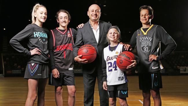 NBL owner and executive chairman Larry Kestelman alongside junior basketball players Elle Ferguson, 13, William Davie, 14. Neve Swain, 10 and Luke Moore, 14 as he and the Tasmanian state government today announced that the leagues 10th team would be based in Tasmania. Picture: Zak Simmonds