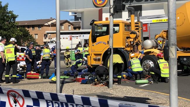 Paramedics work to free the woman from under the truck. Picture: Madeline Crittenden