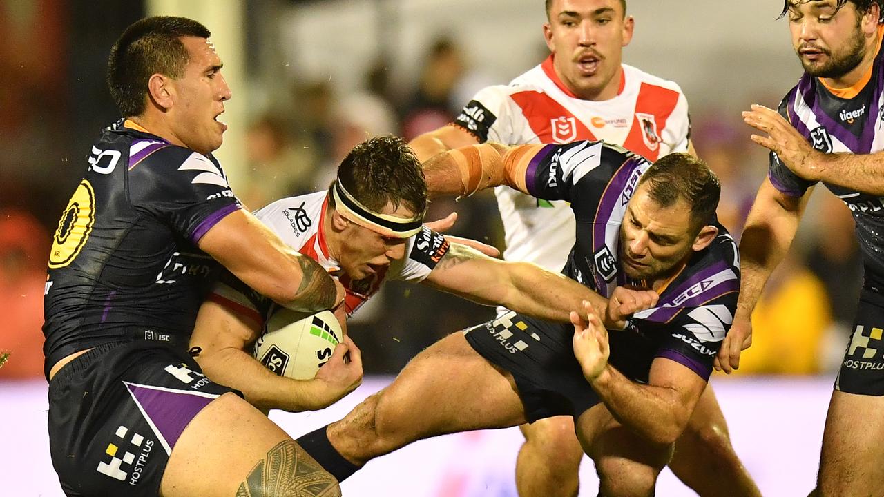 Cameron Smith and Nelson Asofa-Solomona of the Storm tackle Cameron McInnes of the Dragons.