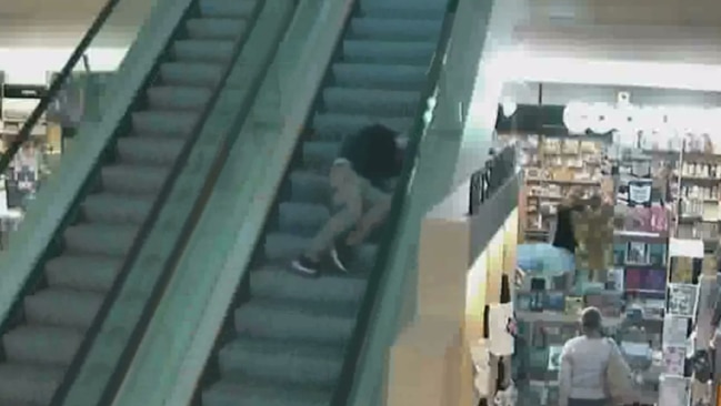 The staff member, seen lying on a moving escalator, is believed to have suffered a mild concussion after the assault. Picture: Twitter