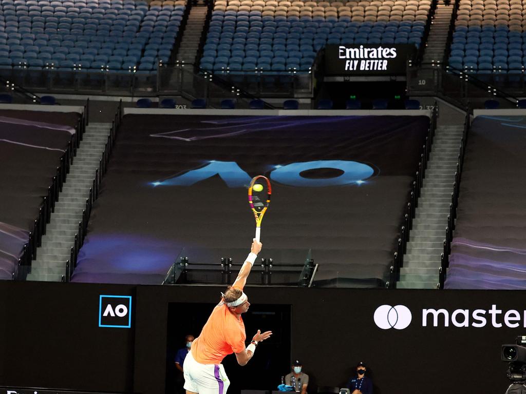 Empty seats are pictured in the background as Spain's Rafael Nadal serves against Greece's Stefanos Tsitsipas during their men's singles quarter-final match at the Australian Open yesterday. Picture: David Gray