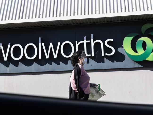 SYDNEY, AUSTRALIA - AUGUST 17: A woman in a surgical mask walks past the entrance to the Woolworths Metro supermarket in North Strathfield on August 17, 2020 in Sydney, Australia. New South Wales remains on high alert as new COVID-19 cases continue to be diagnosed. Customers of the Supermarket are being urged to watch for symptoms after a person who has tested positive for COVID-19 case visited the store over the weekend. The state recorded seven new cases of COVID-19 in the last 24 hours with six locally-acquired and one in hotel quarantine. (Photo by Brook Mitchell/Getty Images)