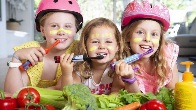 Sisters Kate, Annie, 3, and Maggie, 7, are very good at eating their veggies, brushing their teeth and always wearing their helmets. Picture: Sarah Matray