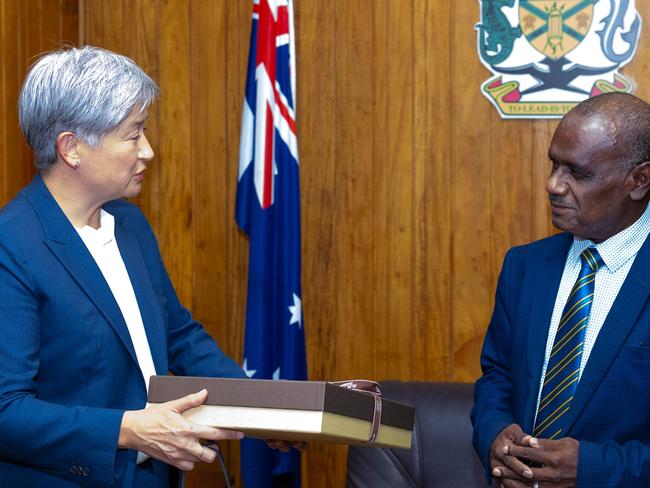 This handout photo taken on June 5, 2024, and released by the Australian Department of Foreign Affairs and Trade (DFAT) on June 6, 2024, shows Australiaâs Foreign Minister Penny Wong (L) handing a gift to Prime Minister of the Solomon Islands Jeremiah Manele, during their talks in the Solomon Islands capital of Honiara. Australia touted a "much bigger" relationship with Solomon Islands, further ramping up efforts to woo a Pacific nation that has lurched closer to China in recent years. (Photo by Handout / Australian Department of Foreign Affairs and Trade (DFAT) / AFP) / - RESTRICTED TO EDITORIAL USE - MANDATORY CREDIT "AFP PHOTO / Australian Department of Foreign Affairs and Trade (DFAT)â - NO MARKETING NO ADVERTISING CAMPAIGNS - DISTRIBUTED AS A SERVICE TO CLIENTS