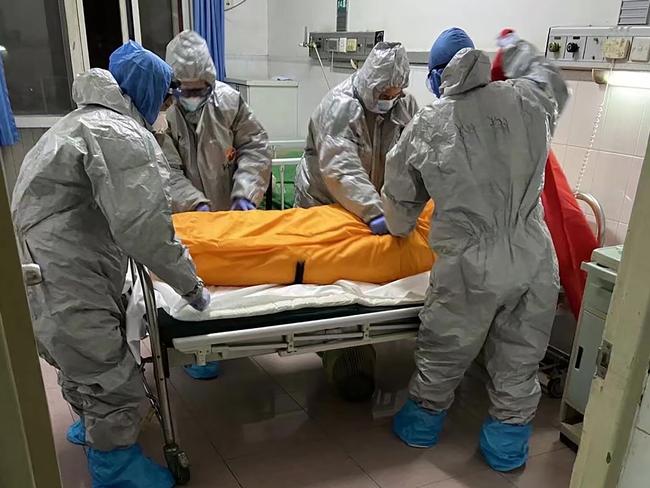 Wuhan medical workers prepare to take away the body of a COVID victim. Picture: AFP