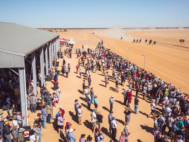 The horses thunder down the home strait at the Birdsville racetrack.