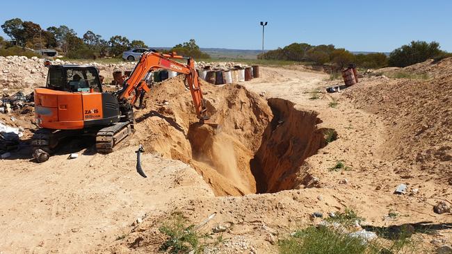 Police use an excavator to search for a car linked to the 1999 murder of three Rebels bikies. Picture: SAPOL