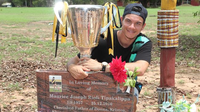 Daniel Rioli with the 2019 Richmond premiership cup at the grave of club legend Maurice Rioli. Picture: Michael Klein