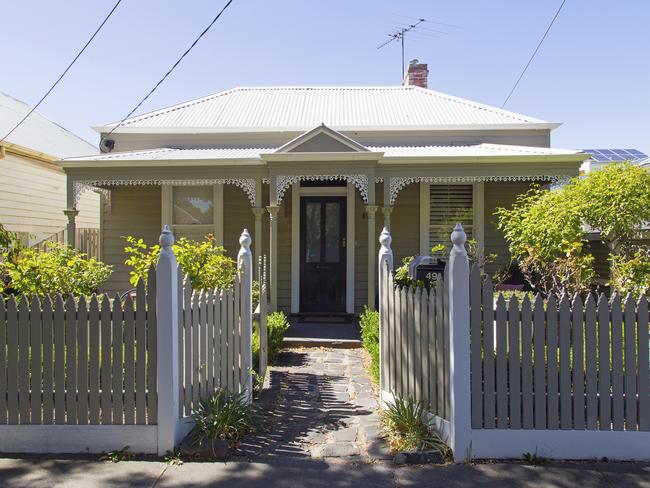 Williamstown, Australia: March 07, 2019: Traditionally built bungalow in the 20th century Australian style in Williamstown with a porch, ornate verandah, garden gate and painted picket fence.