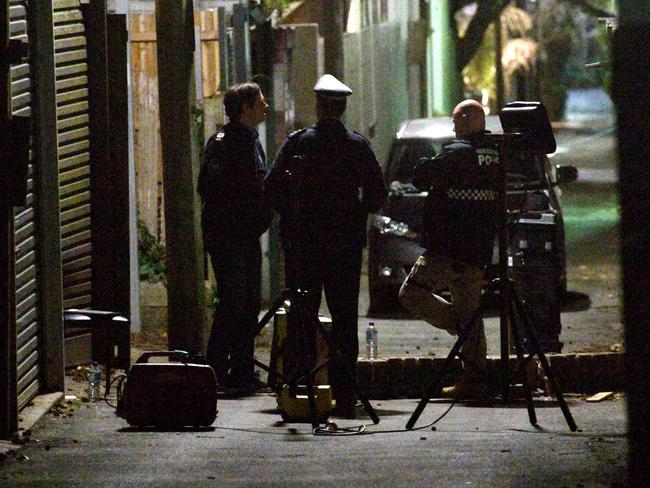 Police work in a lane way behind a house raided during terror raids in Surry Hills.