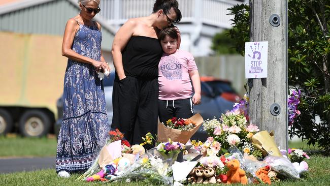 Mourners pay their respects at a makeshift shrine near the scene of the car fire. Picture: AAP