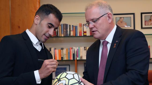 Hakeem al-Araibi signing a ball for PM Scott Morrison. Picture: Gary Ramage