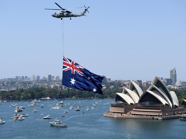 A Royal Australian Navy MH-60R Seahawk helicopter flies an Australian flag over Sydney Harbour during Australia Day celebrations in Sydney, Saturday, January 26, 2019. (AAP Image/ Dan Himbrechts) NO ARCHIVING