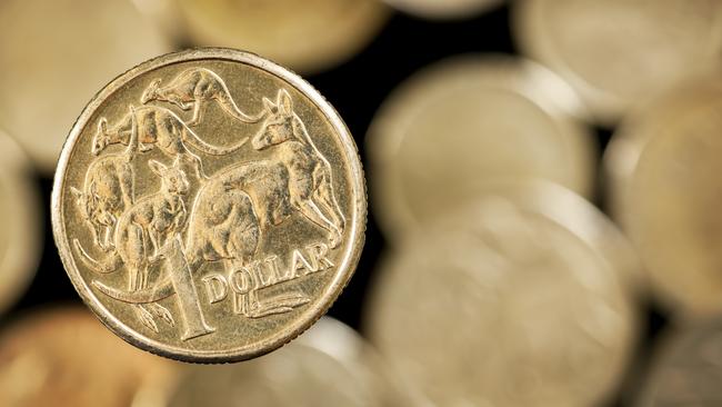 Australian one dollar coin over blurred golden background.