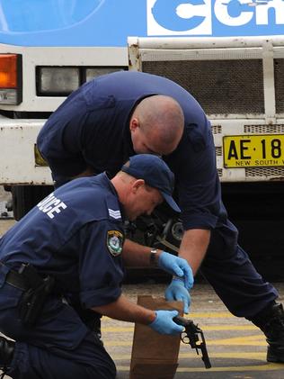 Police seize a gun following the armed robbery at Lane Cove in 2009.