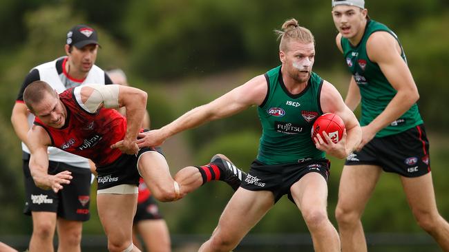 Jake Stringer fends off David Zaharakis at Essendon training.