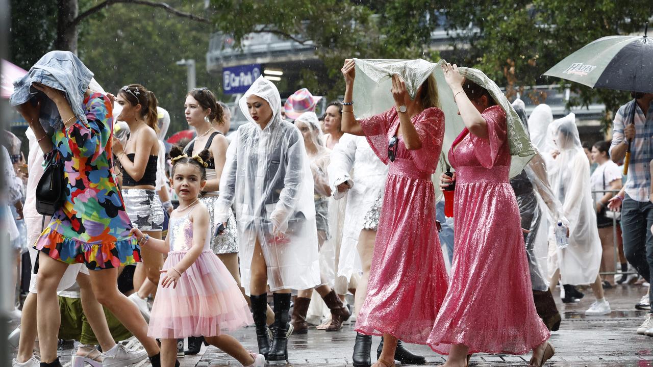 Rain buckets down as Taylor Swift fans head for the entrance. Picture: Richard Dobson