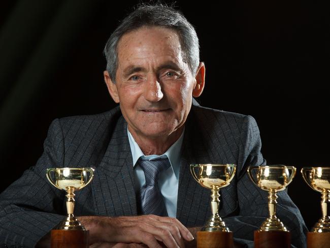 Former jockey Harry White poses with his four Melbourne Cup trophies. White is donating his massive collection of memorabilia to the Victorian Racing Club.