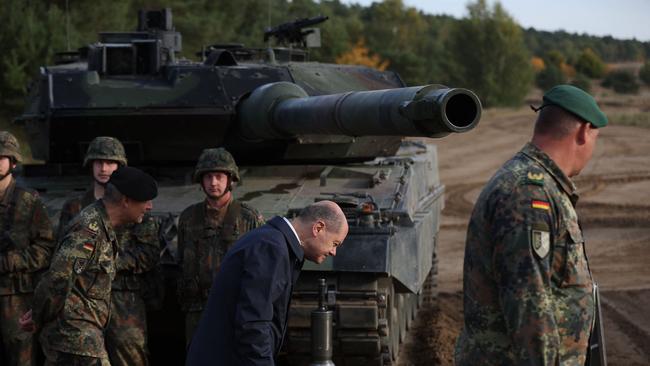 German Chancellor Olaf Scholz, centre, lwalks past a Leopard 2 main battle tank. Picture: AFP