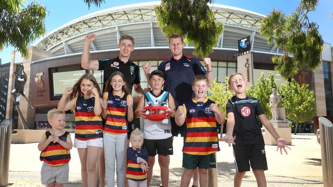 Port Adelaide’s Todd Marshall and the Crows’ Reilly O’Brien with young friends, Milana, 10, Khloe, 10, Jack, 11, Max, 9, Noah, 9, Bodhi, 3, and Saige, 1, are all excited about the upcoming AFL Gather Round. Picture: Dean Martin