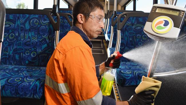 Yoshi Aonuma scrubbing down a Surfside Buslines bus at an Upper Coomera depot. Picture: Lawrence Pinder