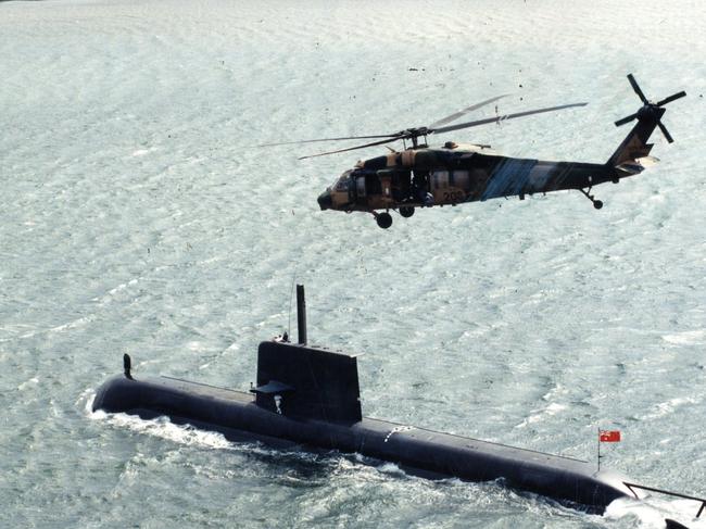 The first Collins-class submarine, HMAS Collins, on sea trials travelling down the Port River, 31 Oct 1994.  Helicopter follows overhead.