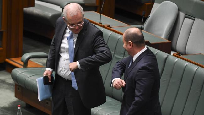 Prime Minister Scott Morrison and Treasurer Josh Frydenberg swap a handshake for an elbow bump in Parliament. Picture: AAP