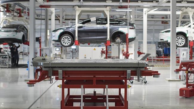 A battery pack stands on a trolley as Tesla Model X sports utility vehicles sit in cradles during assembly for the European market. A boom in electric vehicles made by the likes of Tesla could increase demand for lithium fourfold according to UBS. Picture: Bloomberg