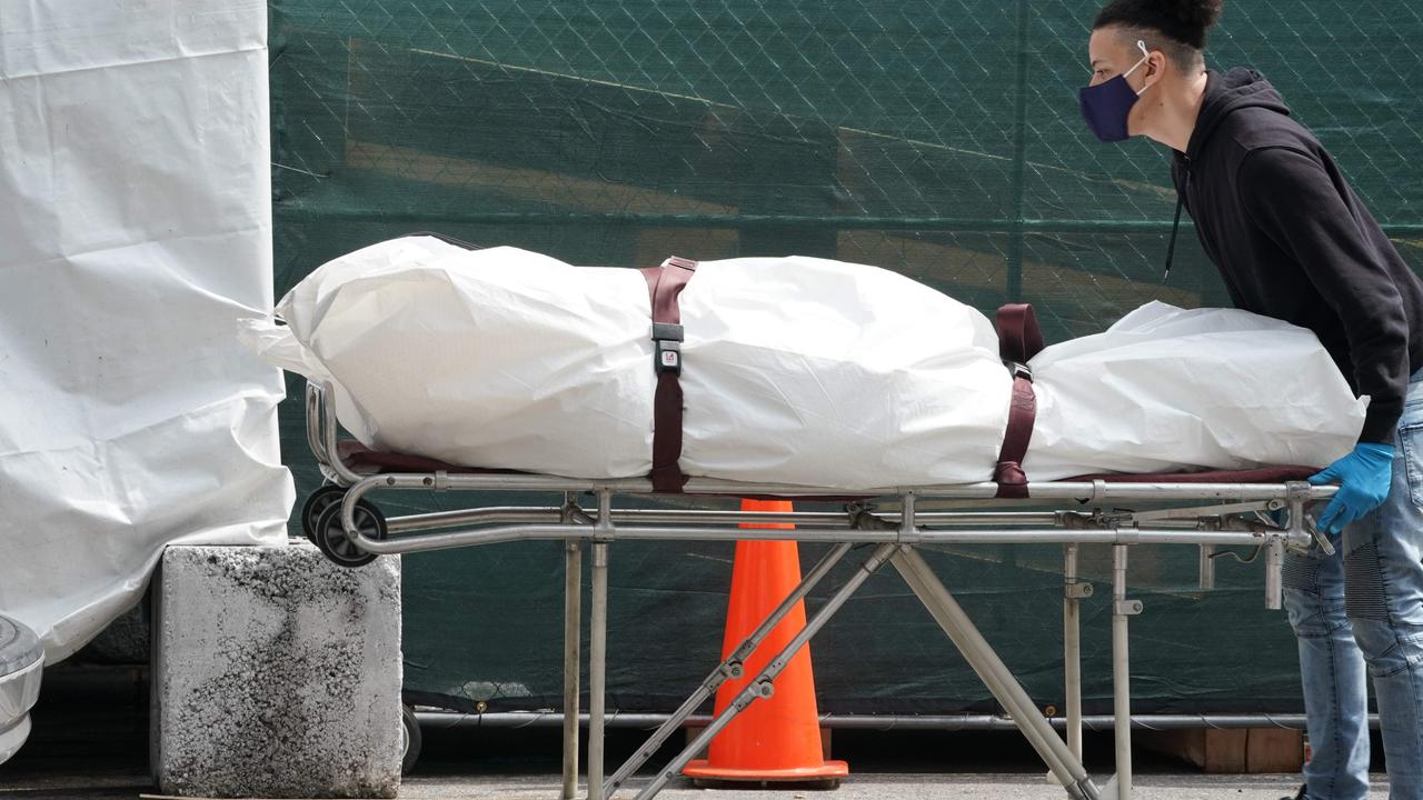 A body is moved from a refrigeration truck serving as a temporary morgue to a vehicle at the Brooklyn Hospital Centre on April 8, 2020. Picture: Bryan R. Smith/AFP.