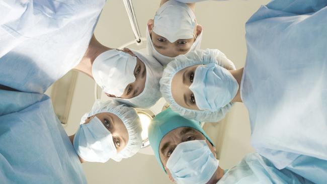 04/08/2011 HEALTH: Generic image of a group of surgeons and nursing staff looking down at patient in an operating theatre.