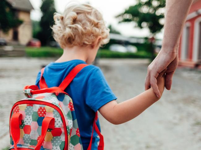 The parent holds the hand of a small child