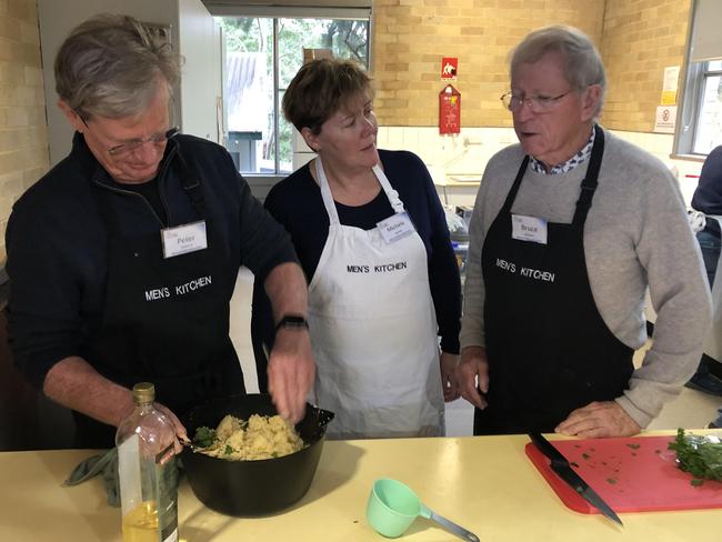 Peter Osborne (left), volunteer instructor Michelle Jansen and Bruce Johnson finish off the Moroccan chicken dish during a Men's Kitchen Northern Beaches cooking skills session at the Forestville Community Hall on Friday. Picture: Jim O'Rourke