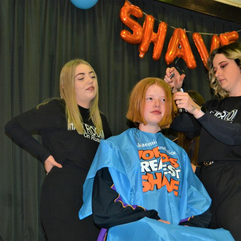 At the St Joseph's College 2023 World's Greatest Shave event is student Ellie Stagg having her hair cut by hairdressers (from left) Abbey McGaw and Natalie Schmidt from the Hair Room on Russell St. Picture: Rhylea Millar