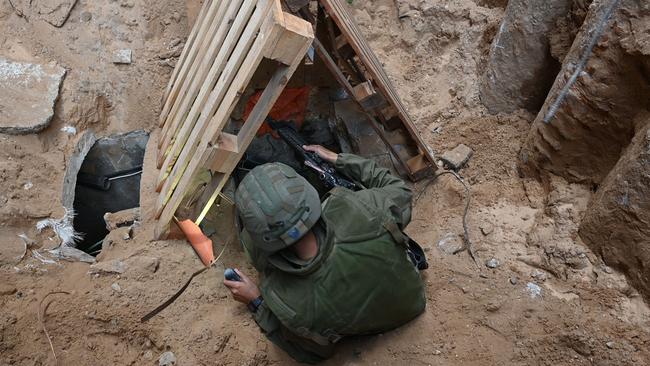 A soldier climbs into what the Israeli army says is the entrance to a tunnel dug by Hamas militants inside the Al-Shifa hospital complex in Gaza City. Picture: AFP