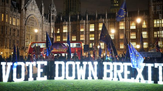 Anti Brexit protesters use illuminated signs outside the Houses of Parliament. Picture: Getty Images.