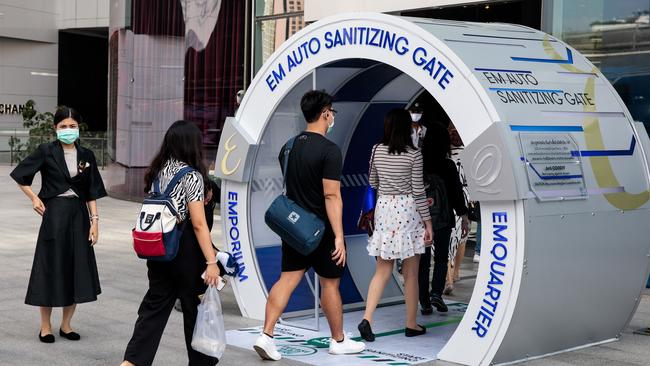 People walk through an 'EM Auto Sanitizing Gate', amid concerns over the spread of the COVID-19 novel coronavirus, outside a shopping centre in Bangkok on March 6.