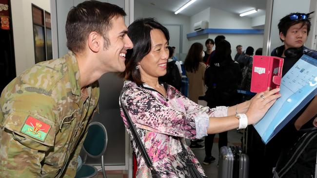 A Wuhan evacuees gets a selfie with a member of Australia’s defence force as she prepares to leave Christmas Island. Picture: Colin Murty