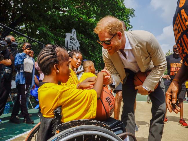 Prince Harry chats to a student at Ilupeju Senior Grammar School. Picture: Getty Images