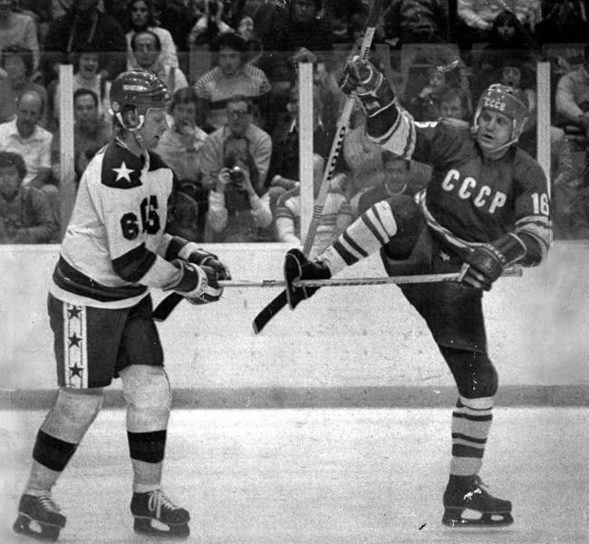 Bill Baker (left) attempts to remove his stick stuck through hole in the skate of opponent Vladimir Petrov during USA v USSR match at the 1980 Lake Placid Winter Olympic Games.