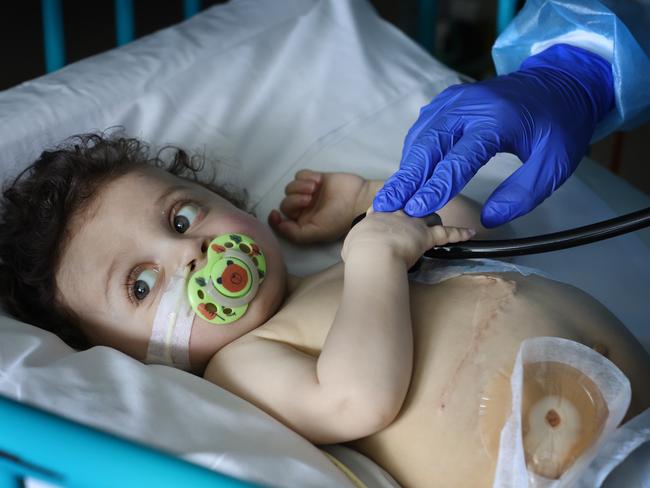 Harlen helps to hold the stethoscope onto his chest during a last check up. Picture: David Caird