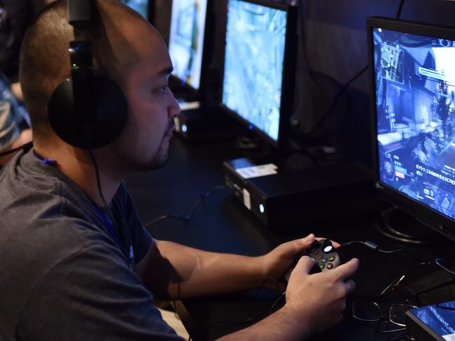 Video game fans play Microsoft's video game console "Xbox One" at a video game cafe in Tokyo on September 3, 2014 on the eve of the launch in Japan. Microsoft Japan will launch the company's latest video game console to the Japanese market on September 4. AFP PHOTO / Yoshikazu TSUNO