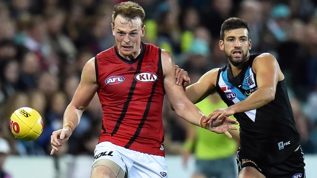 Brendon Goddard gets his kick away in front of Power midfielder Jimmy Toumpas. Picture: Getty