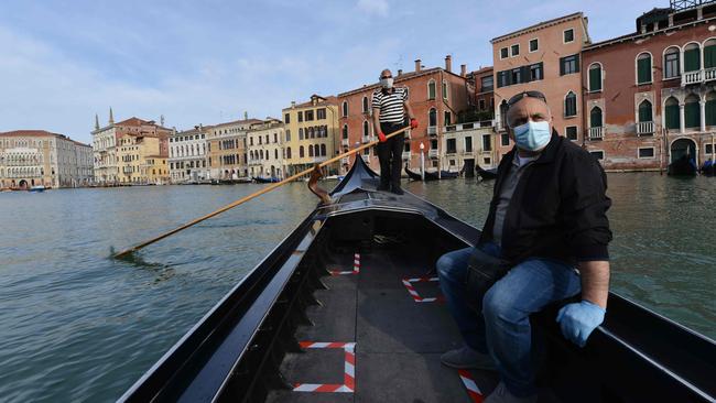 A gondolier, at rear, transports his first customer as service resumes at the San Toma embankment on a Venice canal on May 18. Picture: AFP